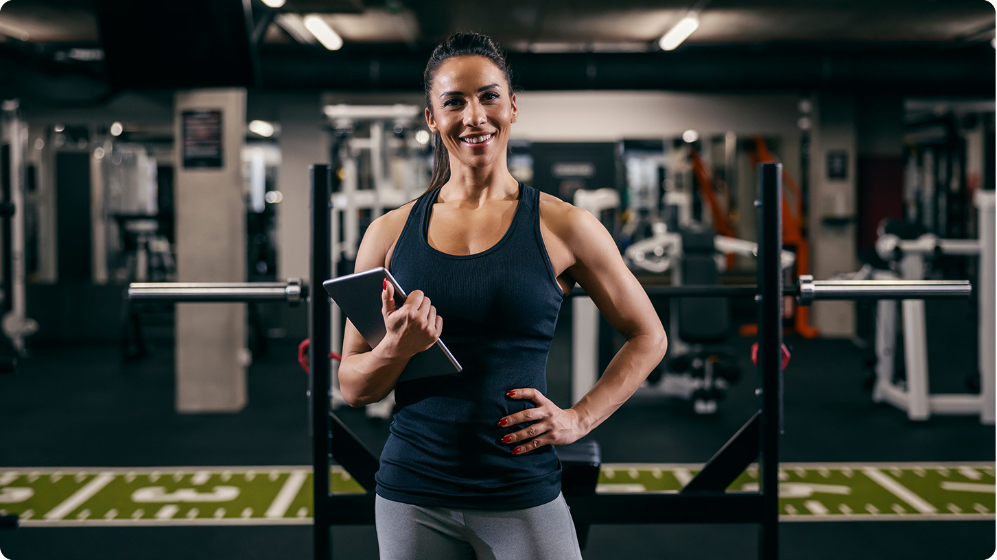 Gym owner standing in the gym using ClubManager on a tablet